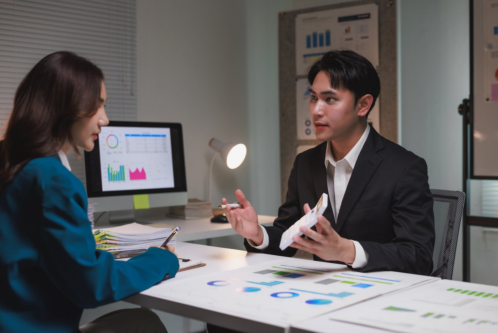 Business colleagues working together, reviewing financial reports and discussing strategy in an office